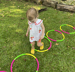 Indie practicing stepping in and out of the hula hoops!
