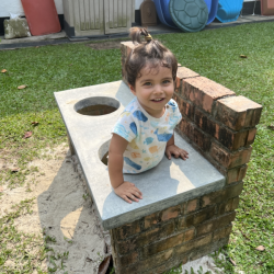 Milan inside our mud kitchen.