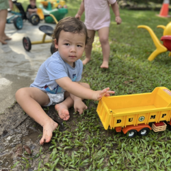 Otto sitting in mud playing with trucks!