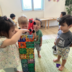 Team work building a very tall tower with the magnetic tiles!