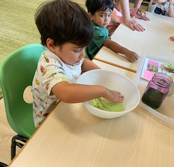 Milan is  kneading the Playdough