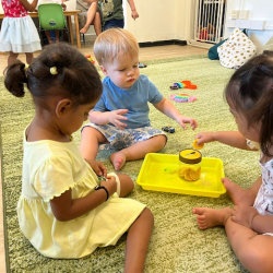 Imaan, Max and Harper taking turns to put the buttons in the jar!