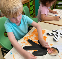 Asher making a Halloween mummy craft