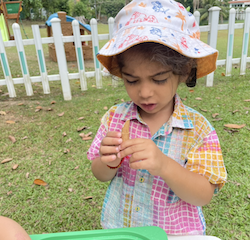 Archish likes the smell of the cinnamon stick in the sensory bin.
