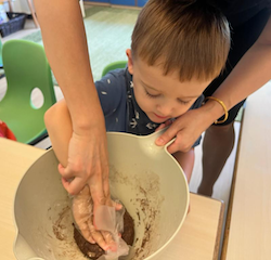 Ms. Grace is helping Ben to make his moon cake.