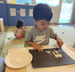 Niko is painting with a toothbrush