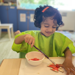 Nila is happily painting her ornament.