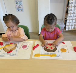 Victoire and Tahlia are making happy and sad faces with play dough.