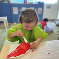Victoire is carefully painting her craft for Deepavali.