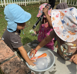 We are mixing, pouring and scooping in the mud kitchen.