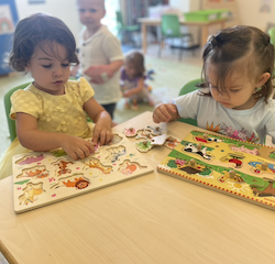 Zaya and Tahlia working on animal puzzles.