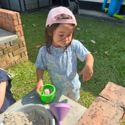 Eden enjoying the mud kitchen.