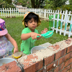 Enjoying the mud kitchen.