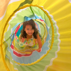 Ruhi is having fun crawling through the tunnel.