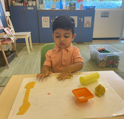 Kai making a snake with play dough.