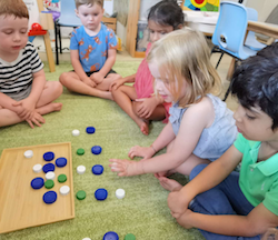 Practising counting with bottle caps.