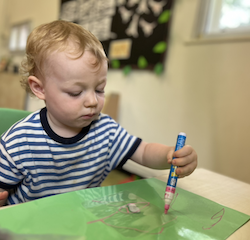 Arthur decorating his plastic sheets with paint markers for his lantern!