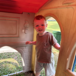Arthur enjoying ducking in and out of houses during outdoor play.