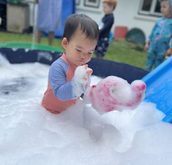 Cara exploring the foam during splash time!