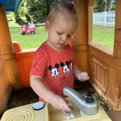 Eleanor taking the snow to the kitchen in the playhouse!
