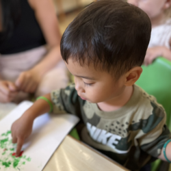 Mateo creating Christmas baubles with finger dots painting!
