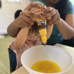 Maya excited on squeezing the honey into the bowl!