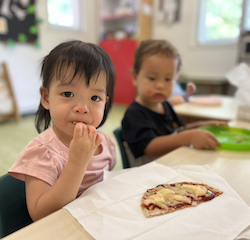 Maya giving her pizza a taste!
