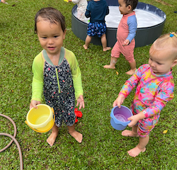 Rowan and Eleanor filling their pails up with water from the hose!
