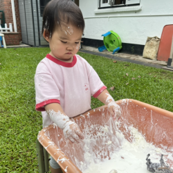 Cara taking delight in messy play!