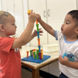 Mateo working together with Eleanor in stacking pegs!