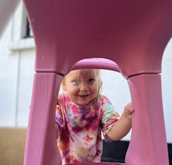 Olivia having fun with push cars outdoors!