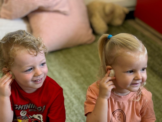 Arthur and Eleanor listening to sounds of the ocean from the shells!