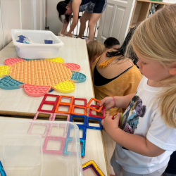 Olivia making a house with square magnets!